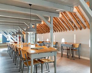 Eetruimte op de bovenverdieping van Vakantiehuisje in Piaam met moderne verlichting, ideaal voor gezellige avonden aan het IJsselmeer.