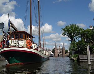 Klipper De Hoop vaart langs historische gebouwen in Akkrum, Friese meren.