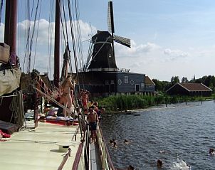 Klipper De Hoop met kinderen zwemmen nabij een molen, Akkrum.