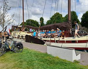 Groep mensen aan boord van Klipper De Hoop, klaar voor avontuur in Akkrum.