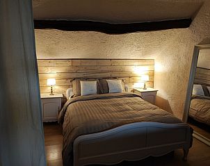 Knusse slaapkamer met houten accenten in Le Petit Nid de Fort, vakantiehuis in Trooz, Ardennen.