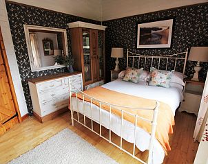 Gezellige slaapkamer in vakantiehuis Five Waterings, Canterbury, Engeland, met rustieke inrichting en comfortabel bed.