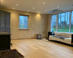 Gezellige woonkamer van Vakantiehuisje in Les Avins-en-Condroz, Ardennen, Belgi, met ruime ramen en uitzicht op de groene tuin.