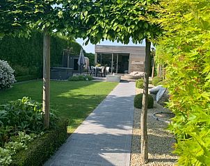 Groene tuin met pad naar Huisje in Havinnes, vakantiehuis in Havinnes, Henegouwen, Belgi, omgeven door weelderige natuur.