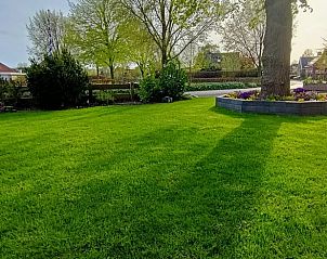 Uitgestrekte tuin van Huisje in Hemelum vakantiehuis in Hemelum, een oase van rust bij de Friese meren.