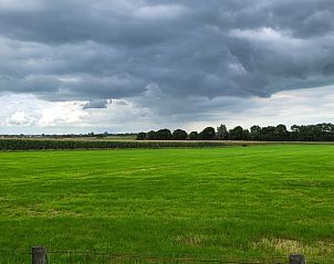 Dreigende luchten boven de velden bij Huisje in Hemelum vakantiehuis in Hemelum, een dramatisch tafereel aan de Friese meren.