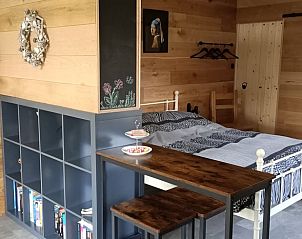 Sfeervolle slaapkamer in Huisje in Hemelum vakantiehuis in Hemelum, met houten accenten en een knusse sfeer.