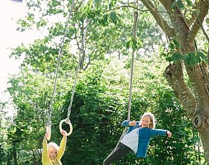Speeltuin met schommels bij Vakantiehuis in Hemelum, kindvriendelijke omgeving in de Friese meren.