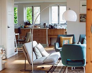 Stijlvolle woonkamer in Vakantiehuis in Hemelum, met veel lichtinval in de Friese meren.