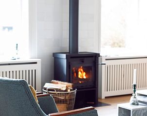 Houtkachel in de woonkamer van Vakantiehuis in Hemelum, knusse warmte in de Friese meren.