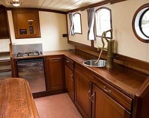 Stijlvolle keuken van bootaccommodatie Vertrouwen in Gaastmeer, Friese meren, met houten afwerking.