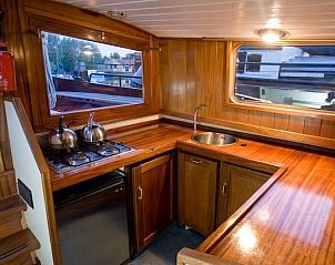Gezellige keuken aan boord van Vrouwe Antje in Gaastmeer, compleet met houten interieur en moderne voorzieningen.