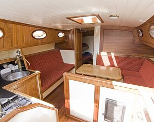 Gezellige binnenruimte van de zeilboot Westwind in Gaastmeer, compleet met keuken en zithoek.