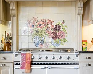Cozy kitchen in Cottage in Yvoir, Ardennes, Belgium with charming tile art and modern cooking facilities.