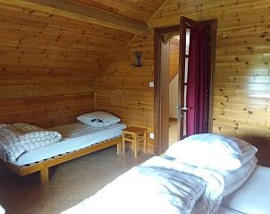 Houten slaapkamer in Chantemerle vakantiehuis, Viroinval, Ardennen, Belgi, met twee eenpersoonsbedden en rustieke sfeer.