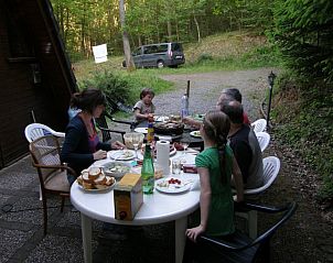 Gezellige buitenmaaltijd op het terras van Chalet Dion in Beauraing, Ardennen, omgeven door natuur.