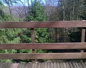 Balkon van Chalet Dion in Beauraing, Ardennen, met uitzicht op de omringende natuur.