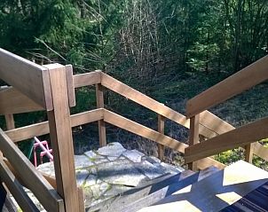 Houten balkon van Chalet Dion in Beauraing, Ardennen, met uitzicht op het bos.