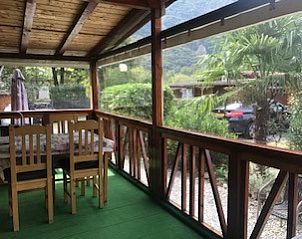 Ontspannen op de veranda van Chalet Porlezza aan het Luganomeer, omgeven door de natuur van de Italiaanse meren.