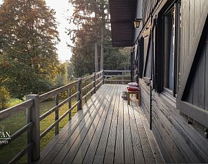 Houten veranda van Chalet Belmont in Vencimont, Ardennen, Belgi, met uitzicht op de omringende bossen.
