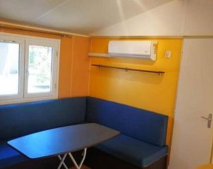 Gezellige binnenruimte van Campingchalet 212 Itali in Camping River Village, Ameglia, Liguri. Comfortabele zithoek met natuurlijke lichtinval.