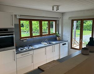 Moderne keuken in Huisje in Marche en Famenne, vakantiehuis in de Ardennen, Belgi, met uitzicht op groene tuin en veel natuurlijk licht.