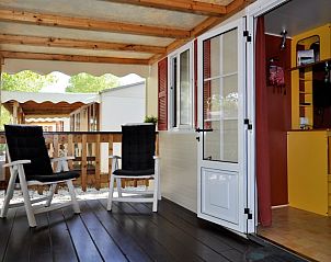 Geniet van de rust op de veranda van een stacaravan in Viareggio, Toscane, Itali, met comfortabele stoelen en uitzicht op de natuur.