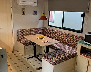 Gezellige binnenruimte van Comfort campingchalet Paradiso 028 in Toscane, met kleurrijke zithoek en uitzicht op de omgeving in Viareggio.