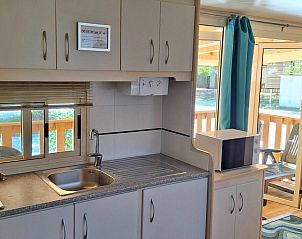 Gezellige keuken in Campingchalet Toscane, een stacaravan aan zee in Viareggio, Itali, met uitzicht op het terras en veel natuurlijk licht.