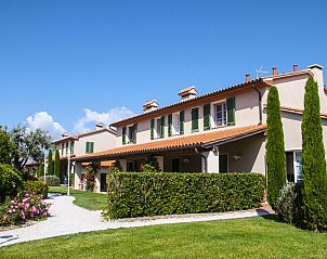 Agriturismo Le Gorette vacation home in Cecina Mare, Tuscany, surrounded by green gardens and blue sky.