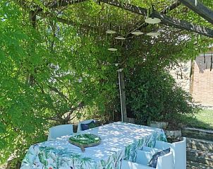 Cozy outdoor area at Casale LA MEMORIA, vacation home in Saturnia, Tuscany, with a shaded veranda for relaxation.