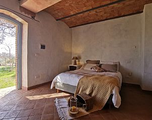 Cozy bedroom in Casale LA MEMORIA, vacation home in Saturnia, Tuscany, with rustic interior and views of the green surroundings.