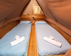 Cozy bedroom in Air Dreamer 3, a glamping lodge in Cavriglia, Tuscany, with comfortable beds and wooden interior.