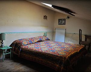 Gezellige slaapkamer in Vakantiehuisje in Santa Fiora, Toscane, met kleurrijk beddengoed en rustieke inrichting.