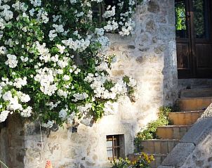 Huisje in Santa Fiora, een charmant vakantiehuis in Toscane, met stenen gevel en bloeiende bloemen in de rustieke omgeving.