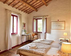 Gemtliches Schlafzimmer in der Villa Castelplanio, einem Ferienhaus in Castelplanio, Umbrien, mit rustikalen Holzdecken und Blick auf die Natur.