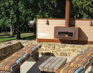 Cozy outdoor sitting area with fireplace at La Ferme des Fermiers, a vacation home in the Ardennes, Ereze.