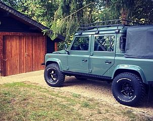 Robuuste terreinwagen naast Vakantiehuisje in Our, Ardennen, Belgi, ideaal voor avonturiers.