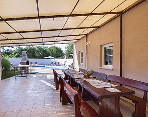 Ontspan op het schaduwrijke terras van Gruppenferienhaus Villa August in Cere, Istri, Kroati, met uitzicht op het zwembad.