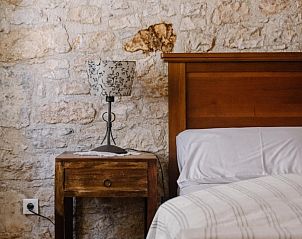 Sfeervolle slaapkamer in Neroli Place, een vakantiehuis in Savicenta, Istri, met rustieke stenen muren en houten meubels.
