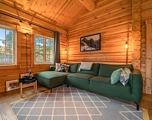 Gezellige woonkamer in Huisje in Vrliosen, Zuid Noorwegen, met houten interieur en comfortabele bank in vakantiehuis.