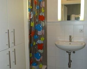 Moderne badkamer in kindvriendelijk vakantieappartement, Bredene, Belgische kust, met kleurrijke douchegordijn en wastafel.