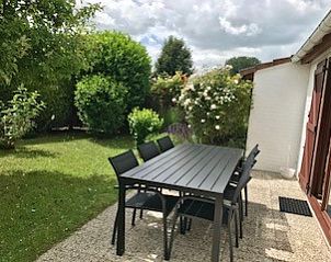 Zonnig terras met tuinmeubilair bij Domein Duinendaele vakantiehuis, Adinkerke, perfect voor buiten dineren.