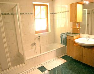 Luxurises Badezimmer im Ferienhaus Fintinn, Httschlag, Salzburg mit modernen Annehmlichkeiten und einem entspannenden Bad.