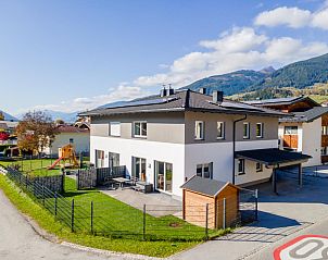 JooP vacation home in Niedernsill, Salzburg, surrounded by snowy mountains and sunny winter landscape.