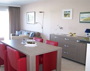Stijlvolle eetkamer in Residentie Lautrec appartement, Bredene, Belgische kust, met moderne meubels en kunstwerken.