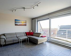 Lichte woonkamer in Huize Oesjoe, Bredene met comfortabele bank en groot raam voor natuurlijk licht.