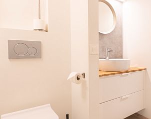 Stijlvolle wastafel en spiegel in badkamer van Appartement op 120m van zee met tuin en parkeerplaats in Koksijde, Belgische kust, Belgi.