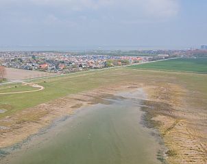 Uitzicht op de natuurlijke omgeving rondom Mer du Nord vakantiehuis in Breskens, Belgische kust, met groene velden en water.