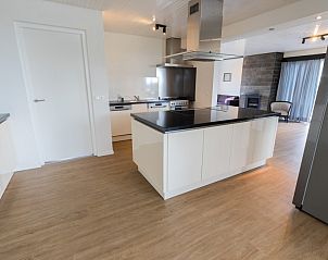 Strakke keuken in Mer du Nord vakantiehuis, Breskens, Belgische kust, met eiland en moderne apparatuur.